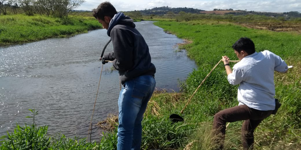 Estudantes de Iniciação Científica do LaBioM coletando a água para ser transportada para o LaBioM e utilizada nos testes de ecotoxicologia com organismos aquáticos